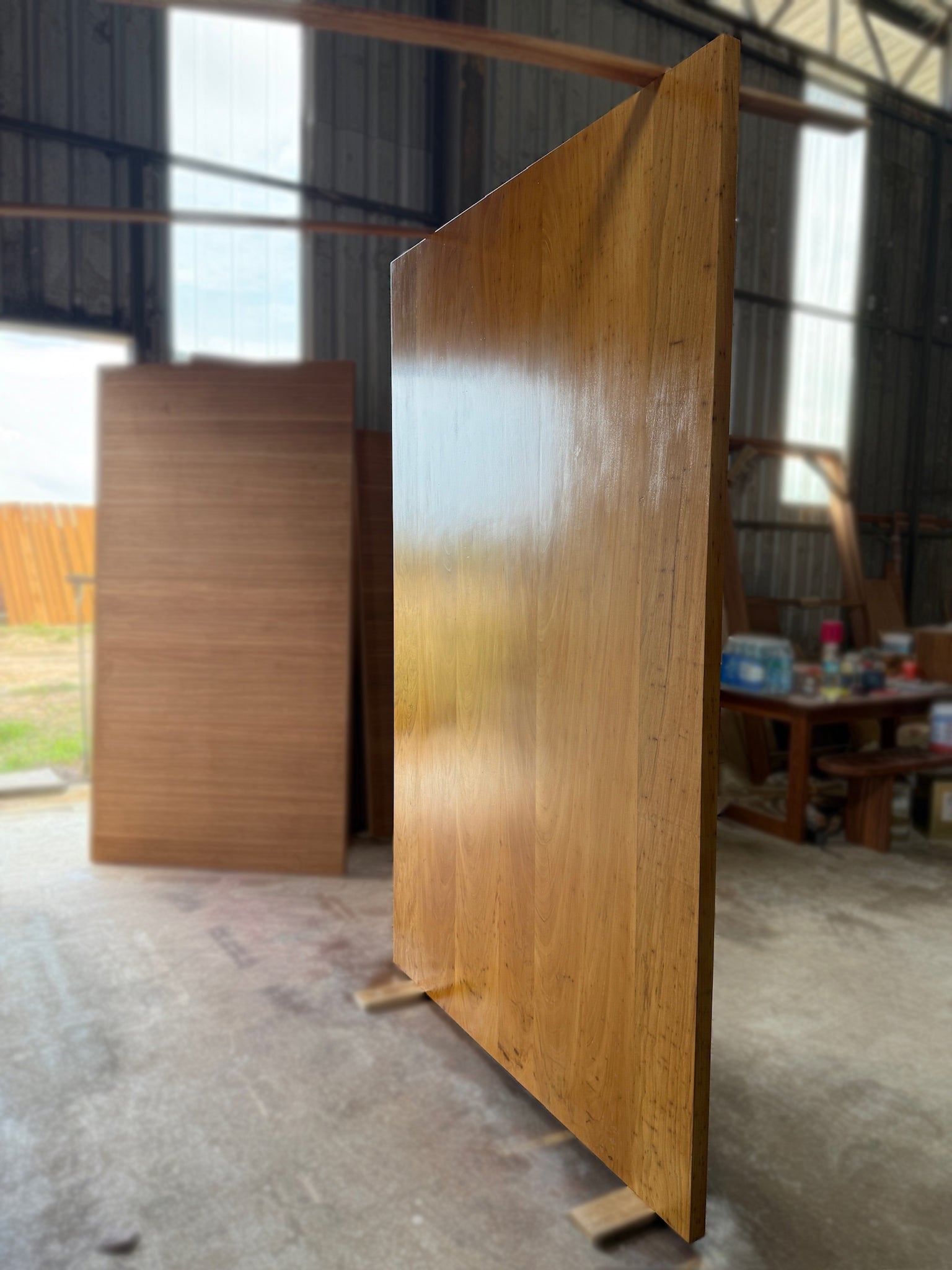 A large pivot door made out of full solid chengal hardwood with lacquer finished.