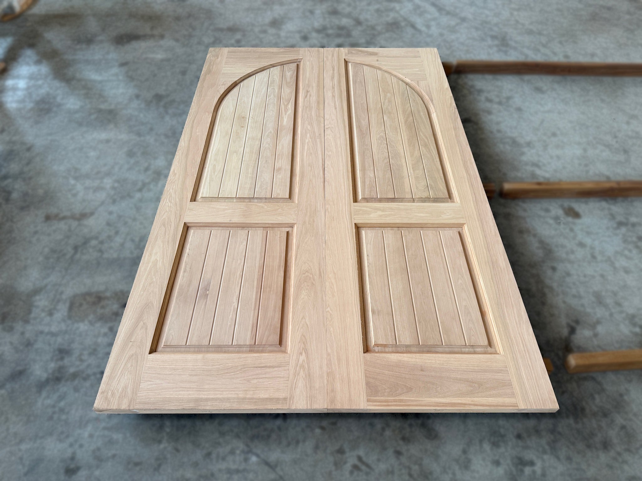 A set of double leaf full solid hardwood doors made out of nyatoh wood putting together after sanding.
