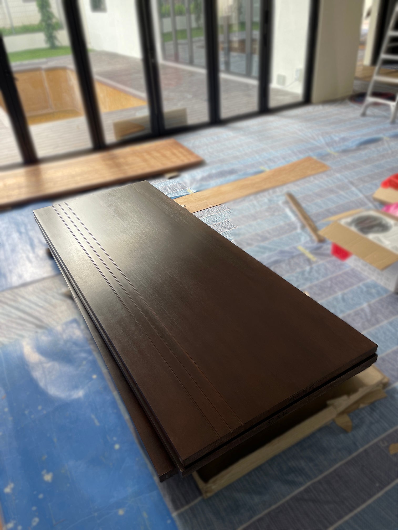 A few pieces of full solid nyatoh hardwood doors with groove lines design and dark stain finished in a renovation site.