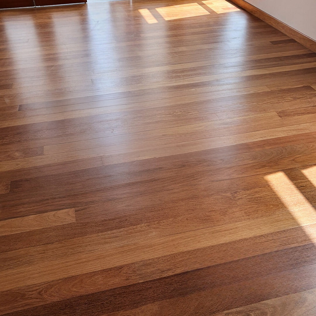 Solid hardwood flooring and skirting made from merbau timber installed, varnished and polished in a room