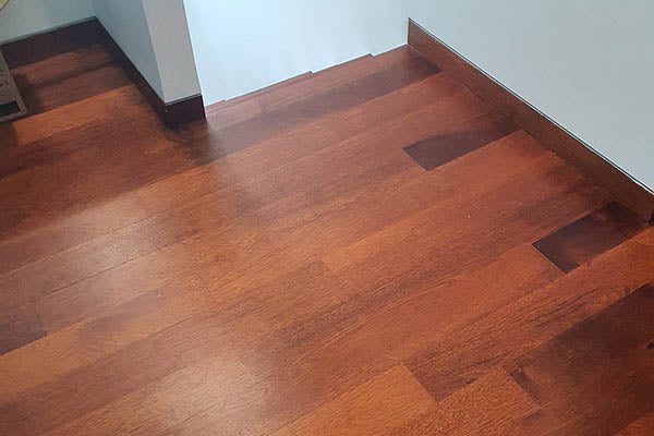 Hardwood flooring and skirting made out of solid merbau wood installed, coated and polished.